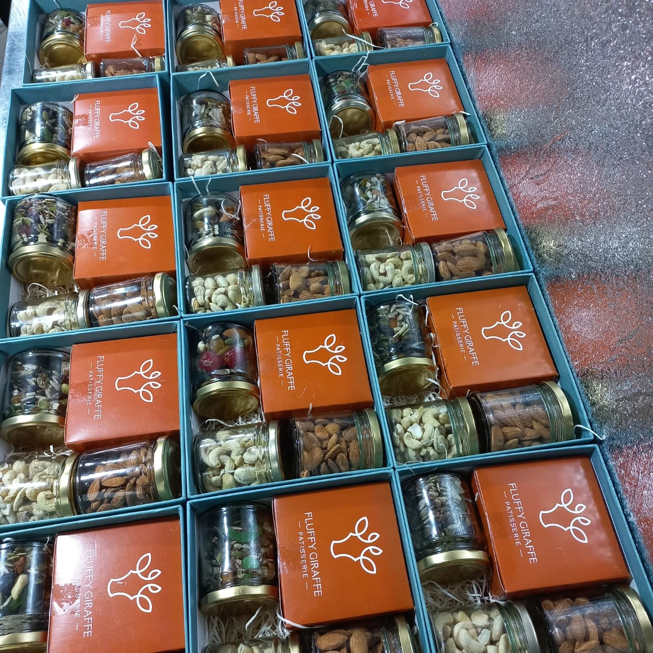 Teal and orange Fluffy Giraffe gift boxes with glass jars of nuts for Diwali gifting